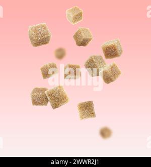 Brown cane sugar cubes falling on pink gradient background Stock Photo