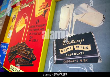 Vintage replica Cadbury's Dairy Milk Advertising signs of their chocolate products on display at the Cadbury's factory  and offices in Bournville, Bir Stock Photo