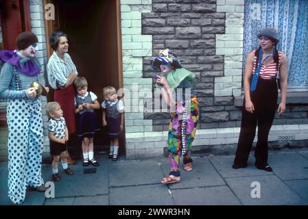 Building  confidence, teen learning new skills. Character building. Clown summer school Tiger Bay area local children learn to act like a clown on the street performing street theatre theater 1980s UK HOMER SYKES. Stock Photo