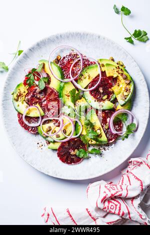 Blood oranges salad with avocado, pistachios and red onions, top view, white background. Stock Photo