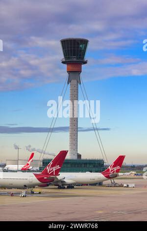 London, England, UK - 30 November 2023: Tail fins of Virgin Atlantic Airways jets parked below the air traffic control tower at London Heathrow Stock Photo