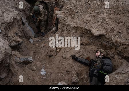 March 15, 2024, Kyiv, Ukraine: Trainees are seen running in a training simulating an evacuation mission in the trench organised by the third separate assault brigade in Kyiv region. Ukraine is facing a shortage of ammunition and military personnel. Aside from a tougher mobilisation law is under way, some brigades in the country have chosen a more encouraging approach to recruit people without previous military experience to join the army. The third separate assault brigade offers a 7-day free training course advertises to allow participants to have a taste of military training, enabling them t Stock Photo