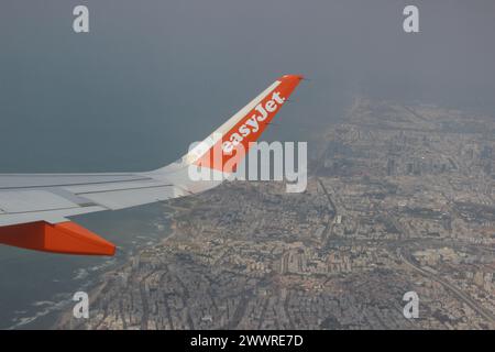 An Easyjet airplane wing flying above the green scenery during spring time in Israel Stock Photo