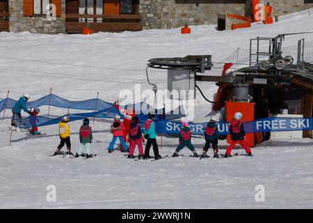 Children learning to ski listen to their instructor at the button lift for the beginner's slope in the Lavachet district of Tignes in the French Alps. Stock Photo