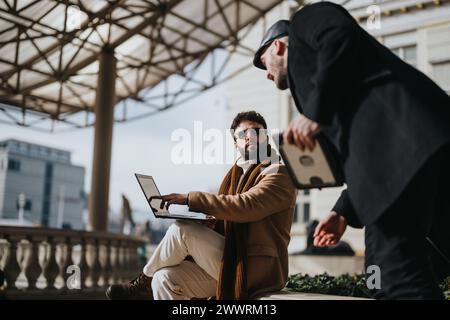 Outdoor business meeting: Two professionals discussing over laptop Stock Photo