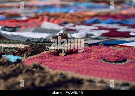 Assorted red, white, and blue blankets stacked on ground Stock Photo