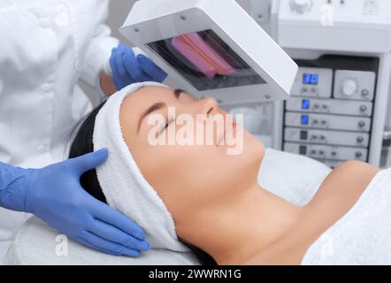 The cosmetologist uses the Wood Lamp for detailed diagnosis of the skin condition. The device detects the presence of skin diseases or inflamed areas. Stock Photo