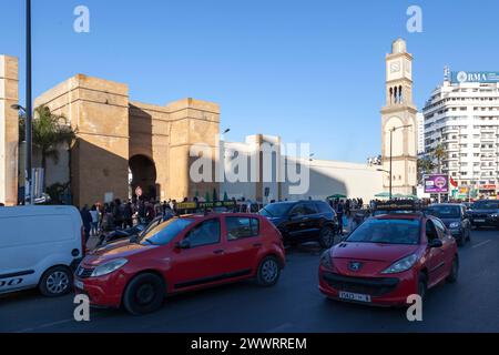 Casablanca, Morocco -  January 17 2019: Two 'Petit Taxi' (Small red taxi operating in some Moroccan cities), near Bab Marrakech and the clock tower of Stock Photo