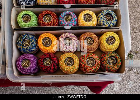 Colorful Handcrafted Yarn Balls Displayed in Cardboard Boxes at Outdoor Market Stall in Quarteira, Portugal. Stock Photo