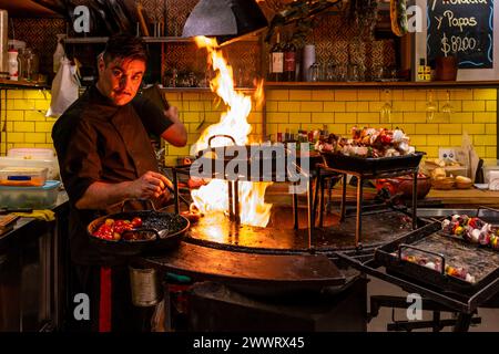 A Chef Cooking Food At A Cafe In The San Telmo Indoor Market (Mercado de San Telmo), Buenos Aires, Argentina. Stock Photo