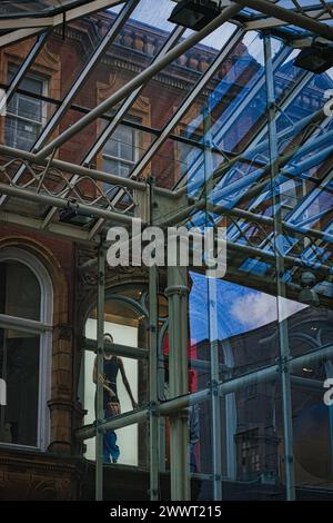 Urban contrast with old brick building and modern glass structure, reflecting city life and architectural diversity in Leeds, UK. Stock Photo