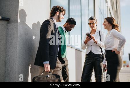 Young startup colleagues collaborating on a project in an urban setting Stock Photo