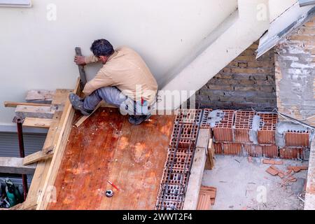 The construction engineer checks the quality of the performed work on the rooftop and terrace structure of the house. Stock Photo