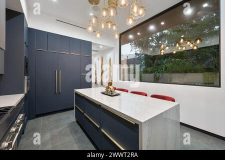 A contemporary kitchen with  blue cabinets and a marble countertop Stock Photo
