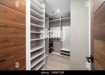 A small walk-in closet with empty shelves or doors Stock Photo