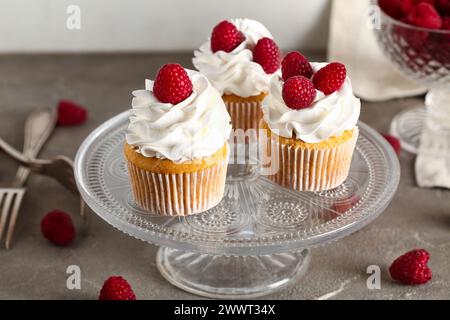 Stand with tasty raspberry cupcakes on table Stock Photo