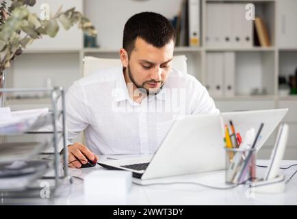 Man office worker using laptop during workday Stock Photo