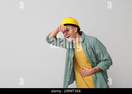 Portrait of happy male engineer laughing on grey background Stock Photo