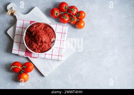 Traditional turkish tomato paste in bowl with fresh tomatoes on rustic table, homemade healthy food Stock Photo