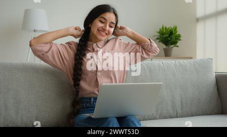 Surprised businesswoman working remote laptop from home office happy Arabian Indian woman girl student studying online winning good exam result Stock Photo
