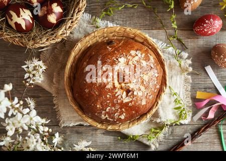 Traditional Czech sweet Easter pastry called mazanec, with eggs dyed with onion peels and decorated  with wax on a wooden table Stock Photo