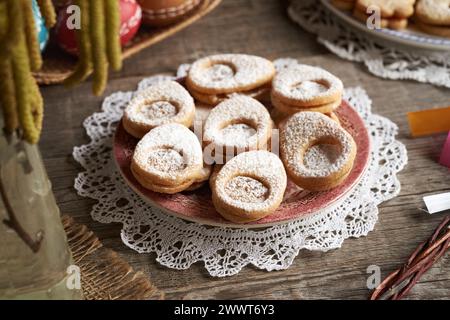 Linzer cookies in the shape of Easter eggs on a plate on a table Stock Photo