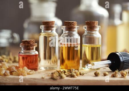 Bottles of essential oils, dry flowers and jar with cream on light ...