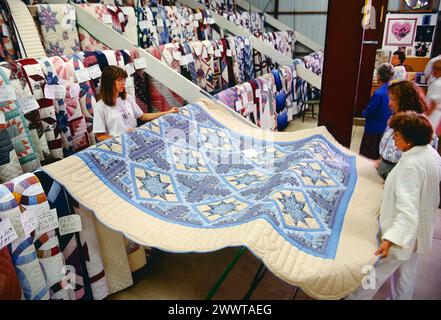 Customers inspect hand made quilts; annual Kutztown Folk Festival; Kutztown; Pennsylvania; USA Stock Photo