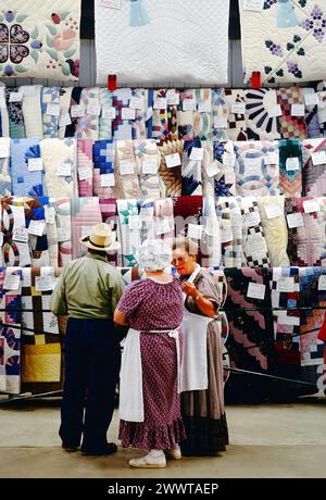 Customers inspect hand made quilts; annual Kutztown Folk Festival; Kutztown; Pennsylvania; USA Stock Photo