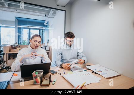 Business professionals collaborating on a project and analyzing statistics in a modern office during meeting. Stock Photo