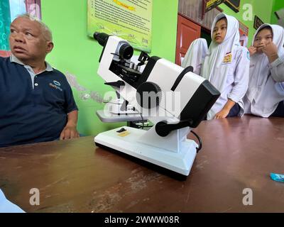 klaten, indonesia may- 2023 volunteers are carrying out free eye health examinations at Islamic madrasah schools, using autorefractor equipment. ophth Stock Photo