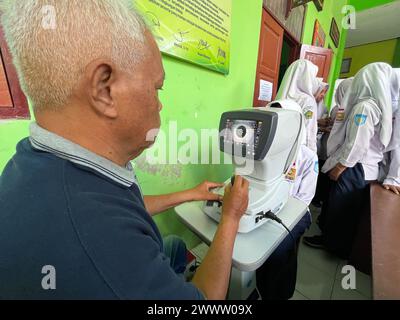 klaten, indonesia may- 2023 volunteers are carrying out free eye health examinations at Islamic madrasah schools, using autorefractor equipment. ophth Stock Photo