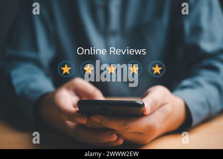 Man hands are shown giving feedback five-star rating on a smartphone customer satisfaction with online reviews questionnaire. Stock Photo