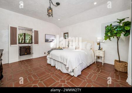 Spacious room with a large bed adorned in crisp white sheets Stock Photo