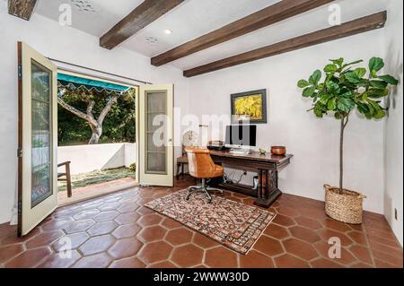 An office space featuring expansive windows, greenery, and a sleek desk Stock Photo