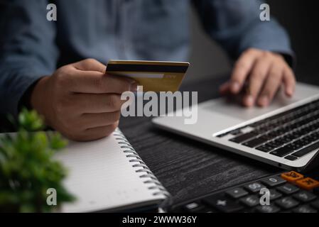 Online Payment Process hands of an individual holding credit card with a laptop for online transactions. Business financial and banking commerce netwo Stock Photo