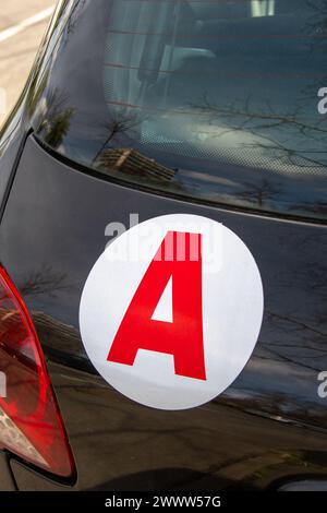 France: “A” sticker disc (for “Apprentice”) on the back of a car, indicating that the vehicle is driven by a young driver Stock Photo