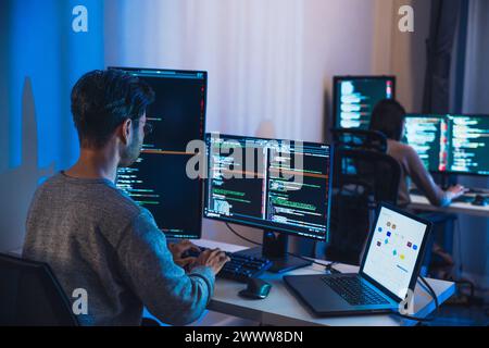 asian woman  and Indian man Developer team working  about devops programming software data online  at night in office Stock Photo