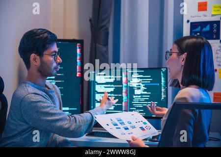 asian and Indian Developer  devops team discussion  about coding promgram with software computer at night in office Stock Photo