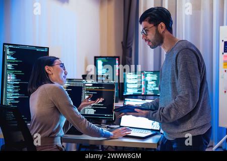 asian and Indian Developer  devops team discussion  about coding promgram with software computer at night in office Stock Photo