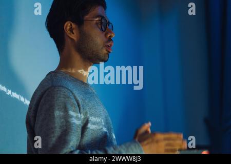 Indian man developer presentation about coding software data with devops team at night in office Stock Photo