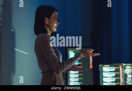 asian woman developer presentation about coding software data with devops team at night in office Stock Photo
