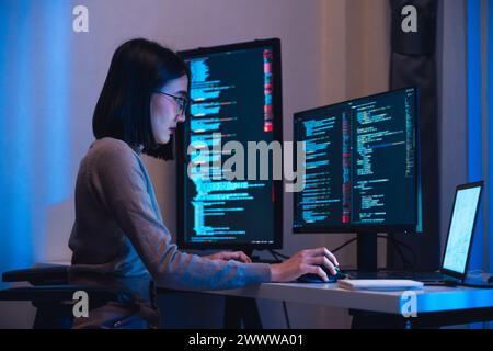 asian woman  developer devops  coding software data working  at night in office Stock Photo