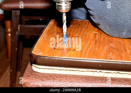 Drill a hole in the board with a drill. Carpentry works. A tool for working with wood. High quality photo Stock Photo