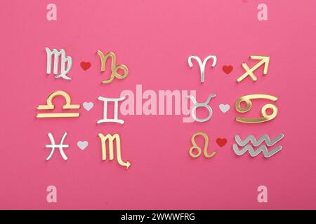 Zodiac signs compatibility on pink background, flat lay Stock Photo