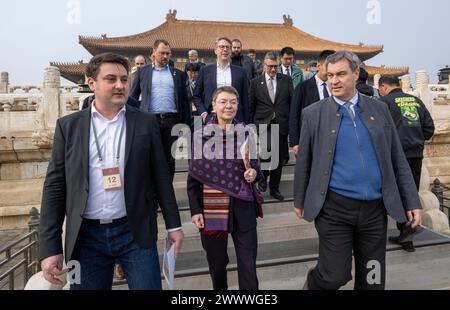 Peking, China. 26th Mar, 2024. Markus Söder (r, CSU), Minister President of Bavaria, visits the historic Forbidden City in the Chinese capital. Söder is traveling to the People's Republic of China until 28.03.2024. He is accompanied by the German ambassador to China, Patricia Flor (M). The site is explained to them by Dominic Hosner (l) from the German Archaeological Institute in Beijing. Credit: Peter Kneffel/dpa/Alamy Live News Stock Photo