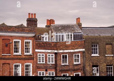 close up of top stories of ancient crooked brick buildings in Windsor England showing different windows and different age buiildings Stock Photo