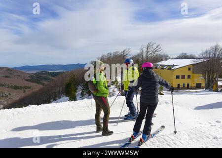 Hiker talking to two skiers, Monte Botte Donato Mountain, Parco Nazionale della Sila, Calabria, Italy Stock Photo