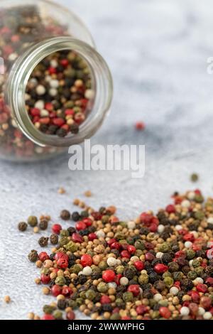 Colorful pepper and corriander spicy mix in jar on the table Stock Photo