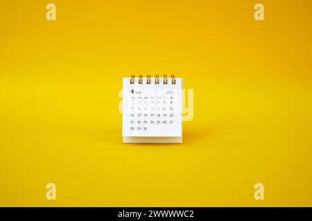 Desk calendar for April 2024 on a pink background with copy space. Stock Photo